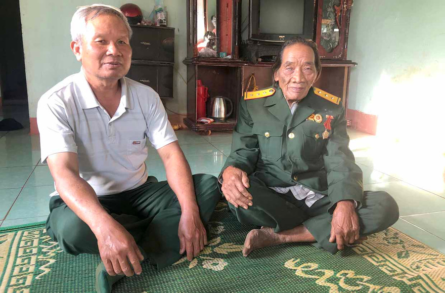 Ông Grơp (bìa phải) cùng ông Nguyễn Quang Toàn ôn lại ký ức những ngày tham gia kháng chiến. Ảnh: Đinh Yến