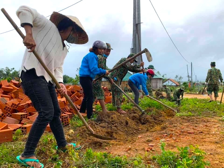 Đoàn viên, thanh niên xã Tú An (thị xã An Khê) cùng lực lượng quân đội đào rãnh thoát nước tại làng Hòa Bình. Ảnh: Ngọc Minh