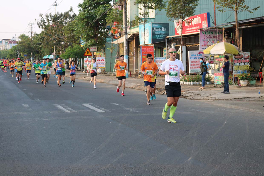 Một vận động viên người nước ngoài tham gia giải với chiếc áo đấu mang thông điệp "Chạy khỏe, sống vui". Ảnh: Phương Duyên 9