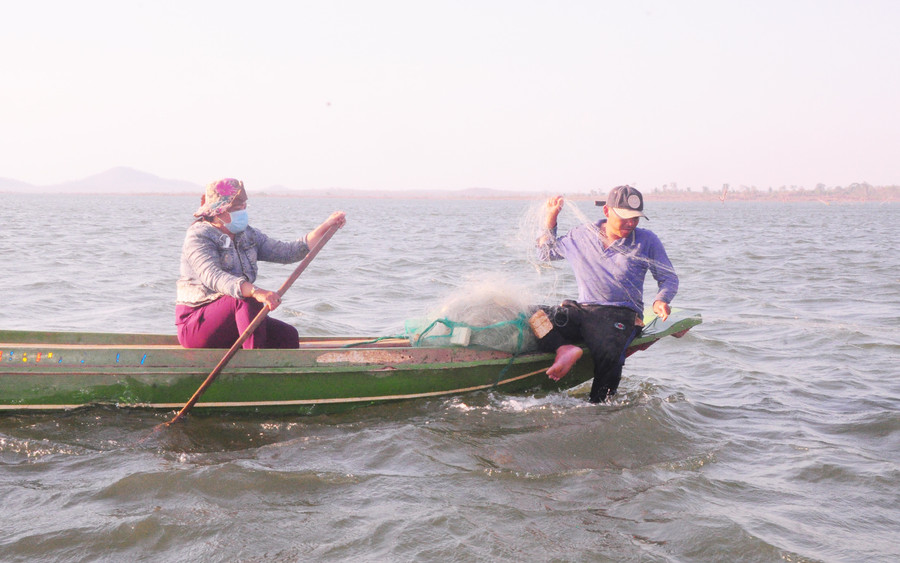 Vợ chồng anh Nguyễn Văn Ninh thả lưới bắt cá trong lòng hồ thủy lợi Ia Mơr. Ảnh: Nguyễn Tú