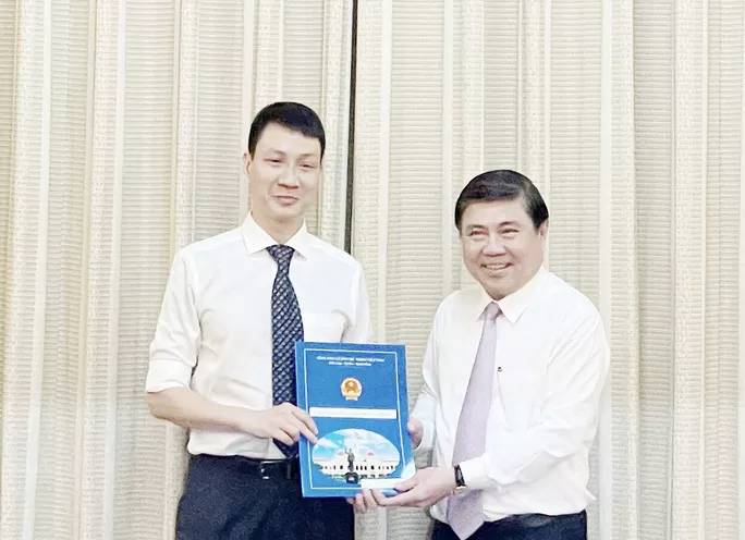 Chủ tịch UBND TP Nguyễn Thành Phong (bìa phải) trao quyết định cho ông Trương Trung Kiên