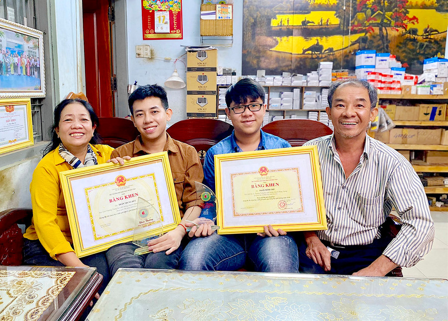 Em Trần Trung Đức (thứ 2 từ trái sang) và Trần Minh Trí chia sẻ niềm vui cùng ba mẹ. Ảnh: Hồng Thi