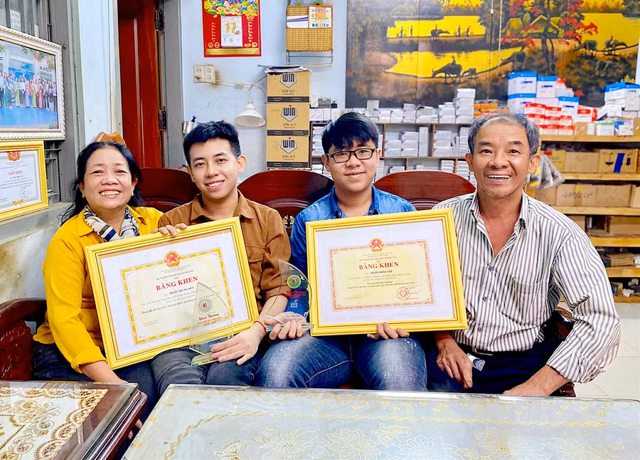 Em Trần Trung Đức (thứ 2 từ trái sang) và Trần Minh Trí chia sẻ niềm vui cùng ba mẹ. Ảnh: Hồng Thi