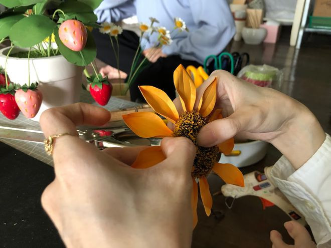 Một bông hoa hướng dương dần thành hình qua bàn tay bé nhỏ của chị Trang. ẢNH: DUY TÂN