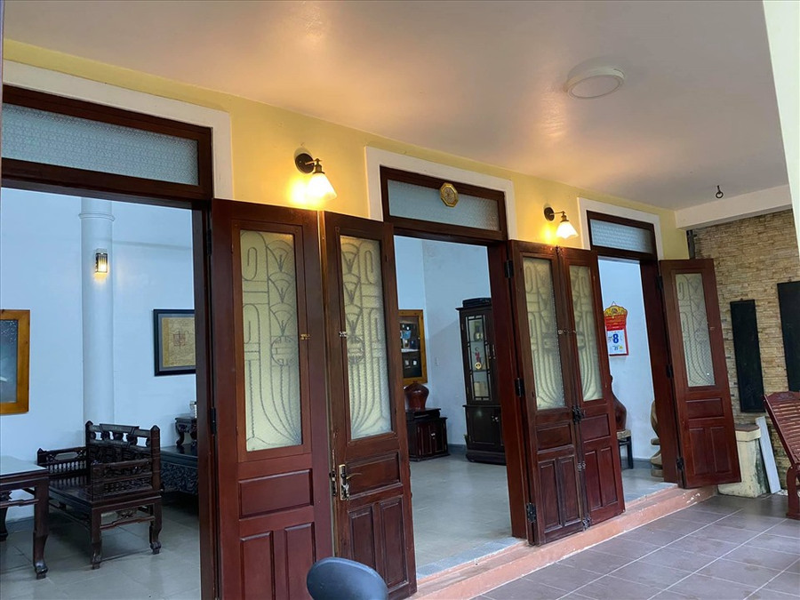 Biệt thự có nhiều cửa rộng và được lắp đèn vàng.