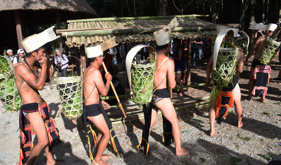 Thanh niên Giẻ Triêng gùi than về làng chuẩn bị cho lễ hội. Ảnh: Tấn Vịnh