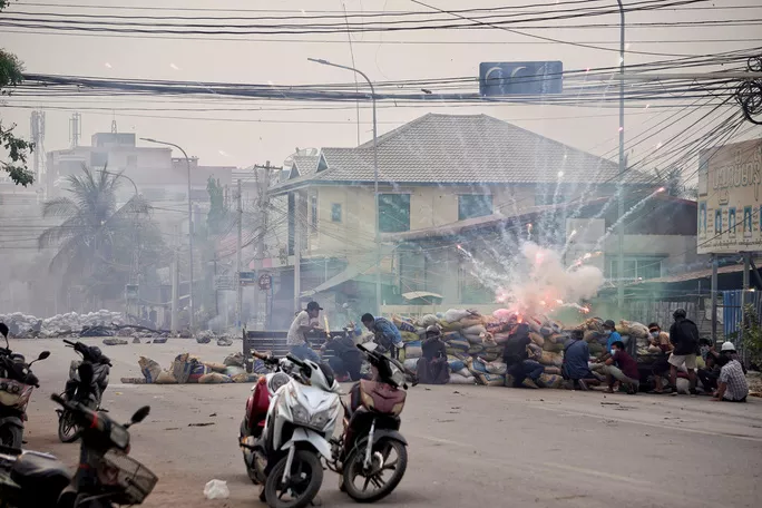Pháo nổ khi những người biểu tình nấp sau một chướng ngại vật ở TP Mandalay vào ngày 21-3. Ảnh: Reuters Pháo nổ khi những người biểu tình nấp sau một chướng ngại vật ở TP Mandalay vào ngày 21-3. Ảnh: Reuters