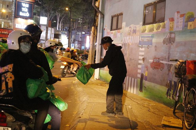 Các thành viên Đội kết nối tình nguyện tặng suất ăn nghĩa tình cho người vô gia cư trên đường phố Các thành viên Đội kết nối tình nguyện tặng suất ăn nghĩa tình cho người vô gia cư trên đường phố