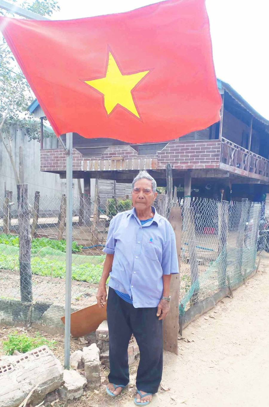 Ông Nay Than treo cờ Tổ quốc trước sân nhà mỗi dịp lễ, Tết. Ảnh: Ksor H'Yuên Ông Nay Than treo cờ Tổ quốc trước sân nhà mỗi dịp lễ, Tết. Ảnh: Ksor H'Yuên