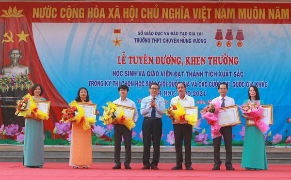 Giám đốc Sở GD-ĐT Lê Duy Định trao tặng bằng khen của Chủ tịch UBND tỉnh cho 6 giáo viên có thành tích xuất sắc trong việc bồi dưỡng học sinh tham dự Kỳ thi chọn học sinh giỏi quốc gia THPT năm học 2020-2021. Ảnh: Hồng Thi.