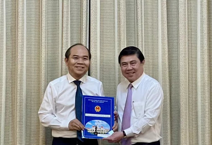 Chủ tịch UBND TP Nguyễn Thành Phong (bìa phải) trao quyết định cho ông Trần Văn Bảy