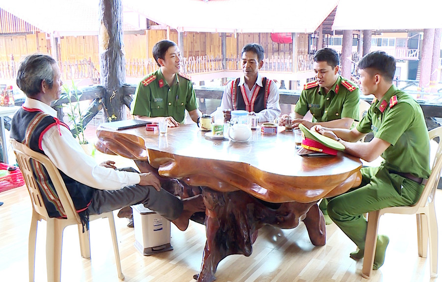 Công an xã Ayun (huyện Mang Yang) gặp gỡ người có uy tín để nắm bắt tình hình an ninh trật tự và phối hợp tuyên truyền pháp luật cho người dân. Ảnh: Nguyễn Hữu