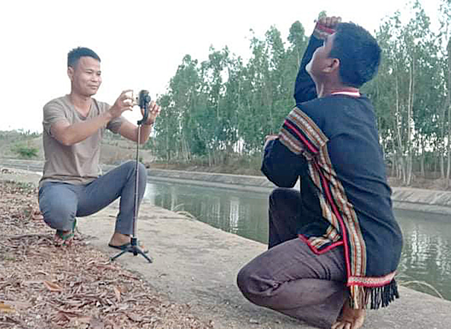 Anh Đinh Phiơt (bìa trái) quay video văn hóa của người dân tộc Bahnar. Ảnh: Thủy Bình 