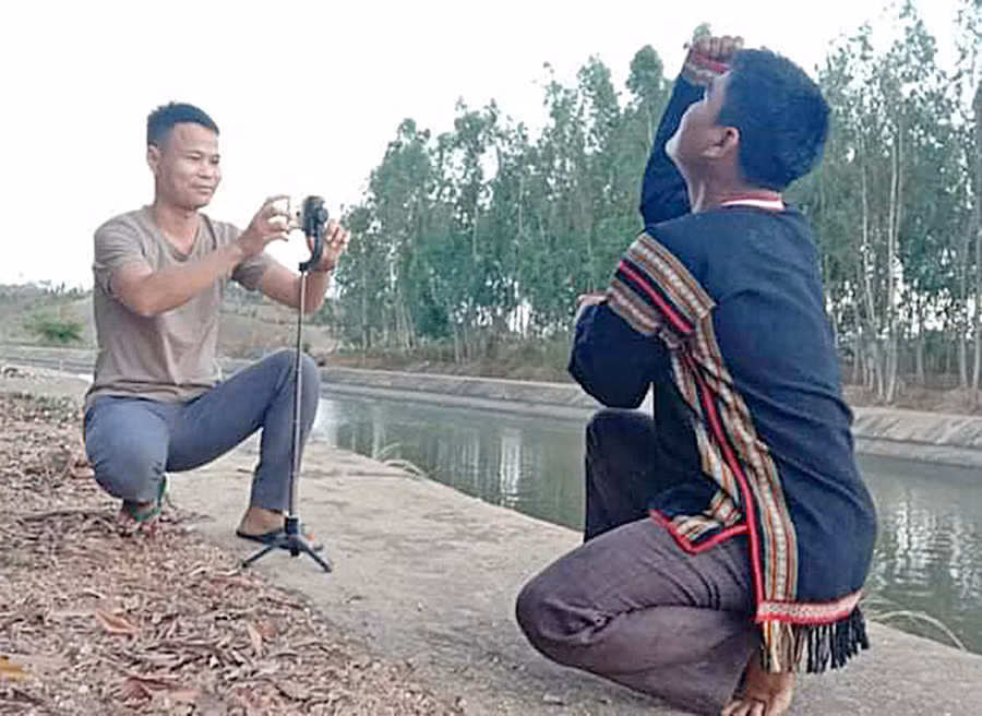 Anh Đinh Phiơt (bìa trái) quay video văn hóa của người dân tộc Bahnar. Ảnh: Thủy Bình 