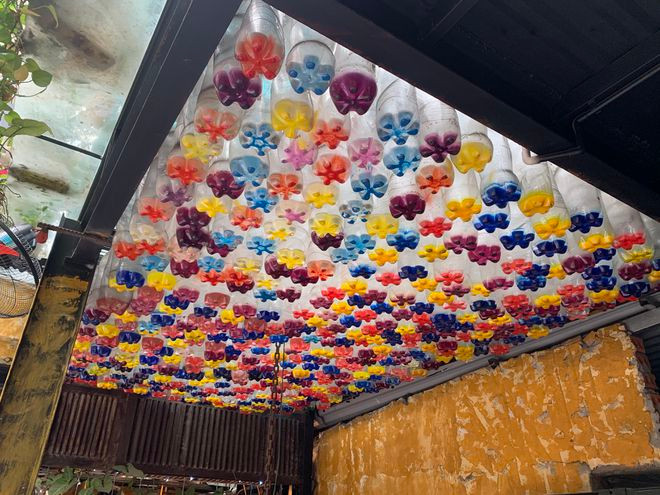 1.000 chai nhựa được vẽ thành các bông hoa làm mái che cho quán. ẢNH KHÁNH HUYỀN