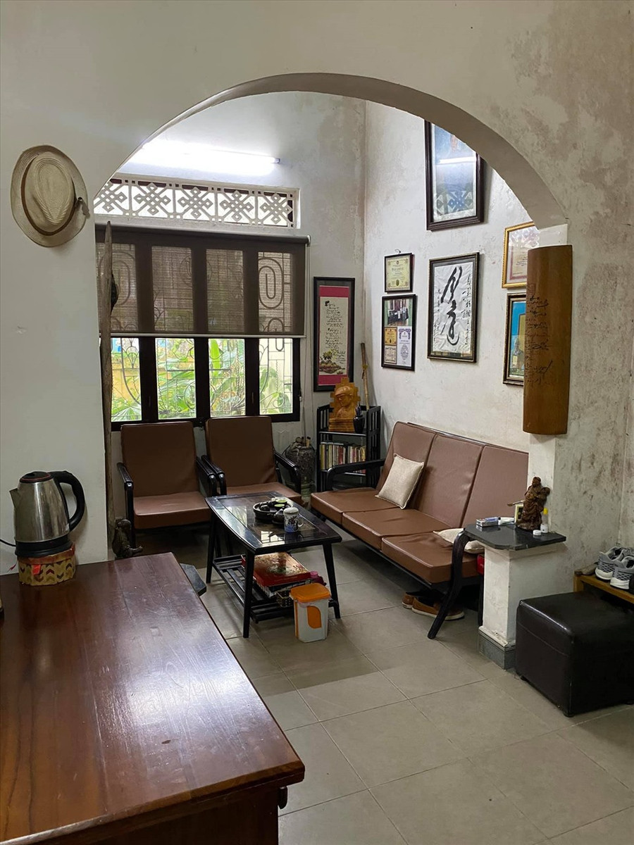 Không gian phòng cổ kính, tông trầm và được bày trí nhiều tranh ảnh.