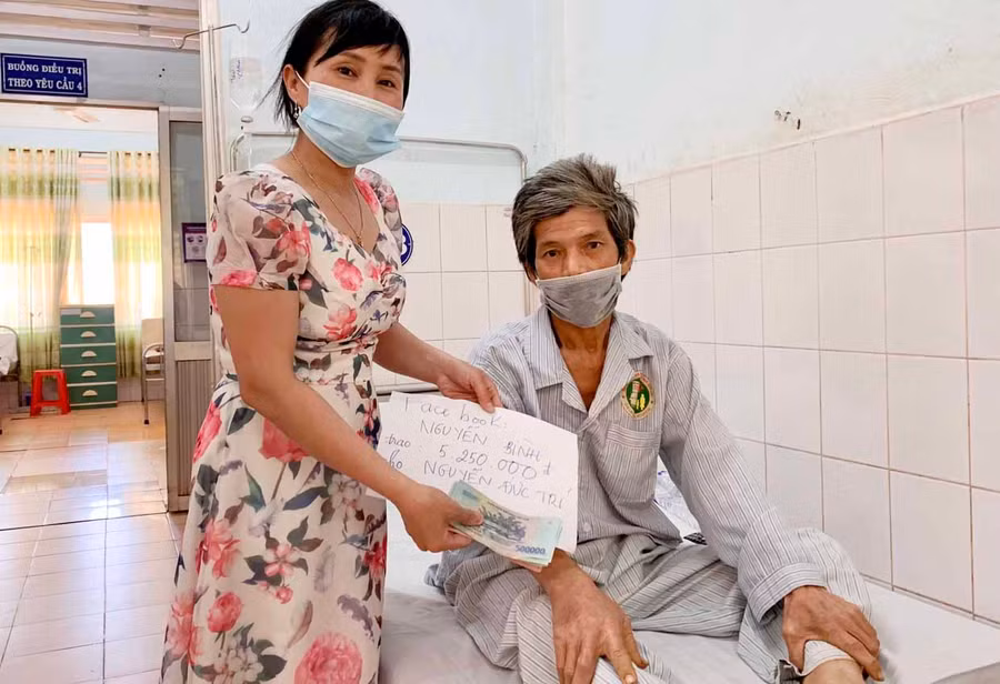 Điều dưỡng Nguyễn Thị Thanh Phương-thành viên Tổ công tác xã hội Bệnh viện Đa khoa tỉnh trao tiền hỗ trợ cho bệnh nhân Nguyễn Đức Trí. Ảnh: Như Nguyện