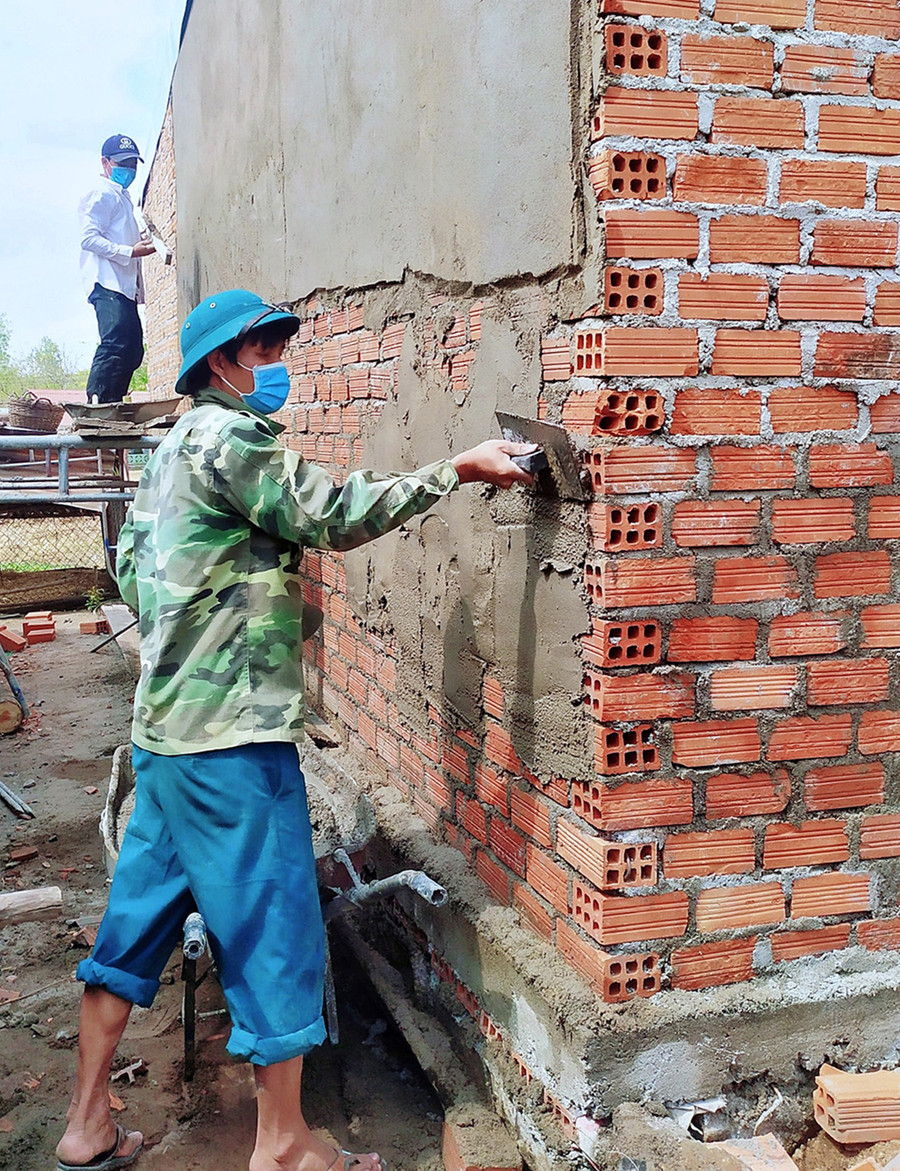 Anh Lê Đình Dinh-Bí thư Đoàn thị trấn Phú Túc (huyện Krông Pa) cùng đoàn viên, thanh niên xây nhà cho hộ khó khăn. Ảnh: Minh Châu