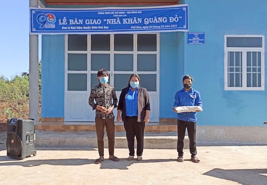 Chị Hà Thị Giang Thảo-Bí thư Tỉnh Đoàn trao nhà Khăn quàng đỏ cho em Kup (bìa trái; học sinh Trường THCS Anh Hùng Wừu, xã Đak Sơ Mei, huyện Đak Đoa). Ảnh: Phan Lài