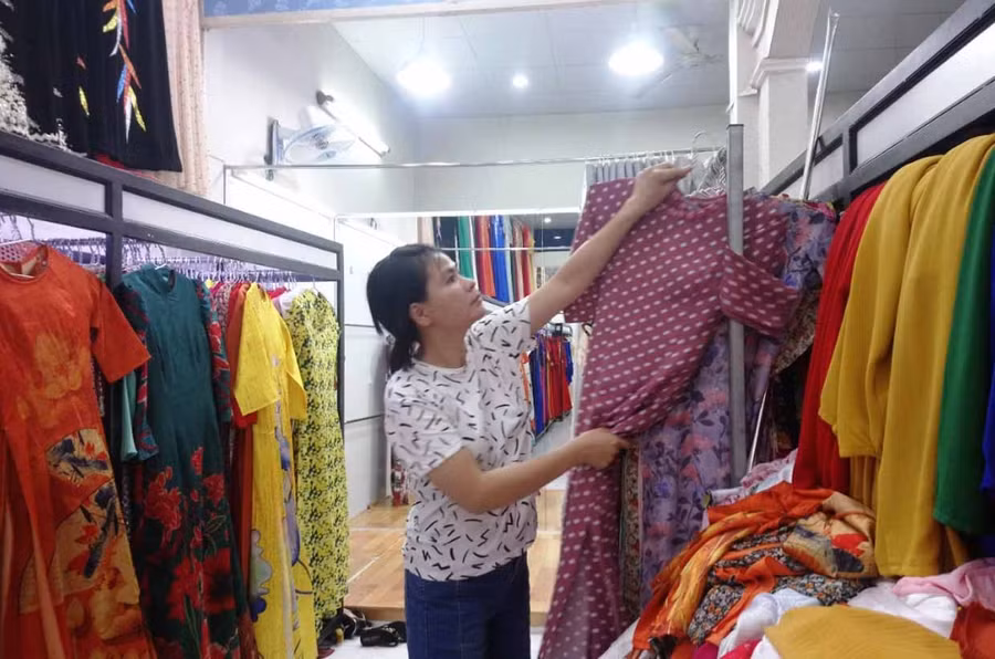 Chị Huỳnh Thị Kim Loan sắp xếp lại áo dài sau khi khách hàng chọn mua. Ảnh: Nhật Hào