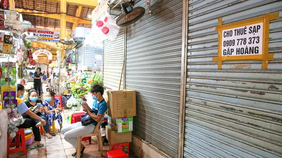 Tiểu thương tụ tập nói chuyện, trong khi nhiều sạp trả mặt bằng hoặc sang nhượng (Ảnh chụp tại chợ Bến Thành ngày 8-3)