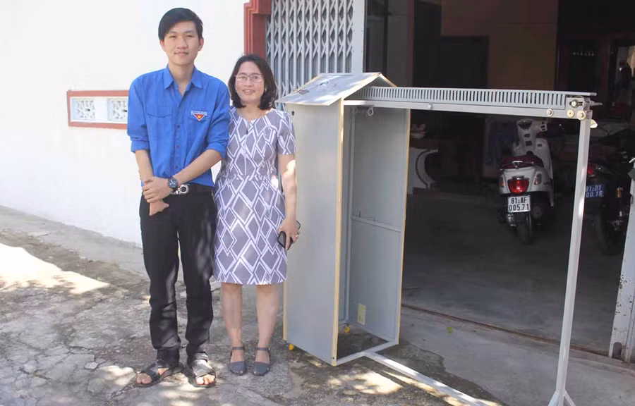 Em Trần Kế Tuấn Vương (Trường THPT Lương Thế Vinh, huyện Kbang) và cô giáo bên chiếc máy phơi đồ do em tự sáng chế. Ảnh: Mai Ka