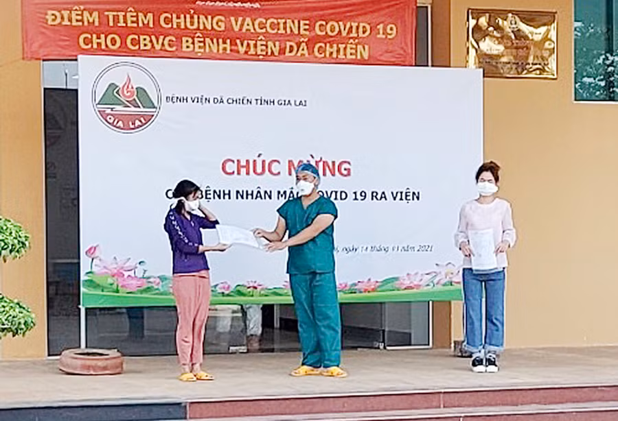 Hai bệnh nhân nhận quyết định hoàn thành thời gian cách ly y tế và giấy ra viện. Ảnh: Như Nguyện