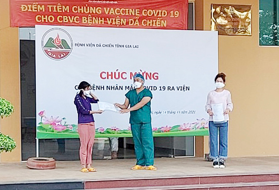 Hai bệnh nhân nhận quyết định hoàn thành thời gian cách ly y tế và giấy ra viện. Ảnh: Như Nguyện