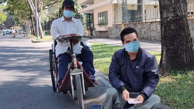 Những lúc bức bối trong gia đình, anh V.D (ngồi lề đường) lên TP.HCM bán vé số cùng nhóm bạn thân ẢNH: NHƯ LỊCH