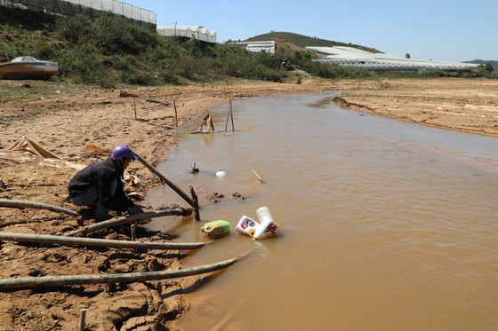 Mực nước hồ cạn khô kéo dài về phía hạ nguồn hàng trăm mét buộc người dân phải đấu nối thêm đường ống để lấy nước tưới cho cây trồng. Ảnh: ĐOÀN KIÊN Mực nước hồ cạn khô kéo dài về phía hạ nguồn hàng trăm mét buộc người dân phải đấu nối thêm đường ống để lấy nước tưới cho cây trồng. Ảnh: ĐOÀN KIÊN