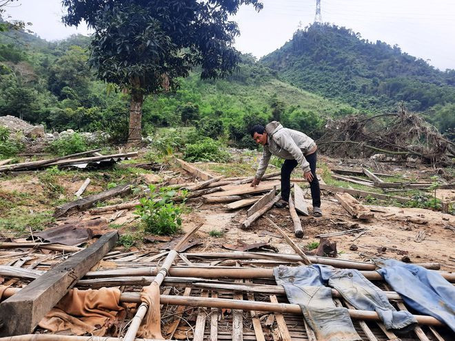 Ông Alăng Dới nhặt lại những gì còn sót lại sau khi căn nhà bị cuốn trôi. Ảnh: MẠNH CƯỜNG