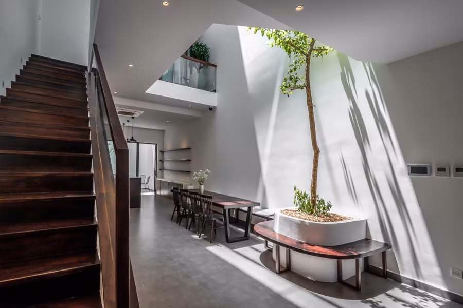 Cầu thang nằm ở giữa nhà, nép sang một bên để mở rộng không gian kết nối. Kế bên cầu thang là giếng trời lấy ánh sáng và thông thoáng.