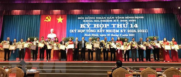 Tặng Bằng khen cho các cá nhân có nhiều đóng góp trong hoạt động của Hội đồng nhân dân tỉnh Bình Định khóa XII. (Ảnh: Phạm Kha/TTXVN)