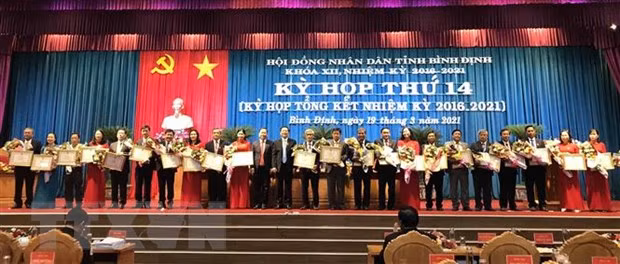 Tặng Bằng khen cho các cá nhân có nhiều đóng góp trong hoạt động của Hội đồng nhân dân tỉnh Bình Định khóa XII. (Ảnh: Phạm Kha/TTXVN)