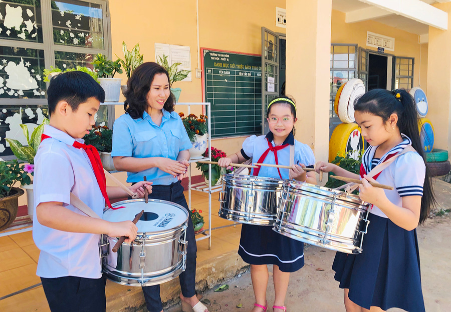 Cô Nguyễn Thúy Hằng hướng dẫn các đội viên đánh trống. Ảnh: Phan Lài