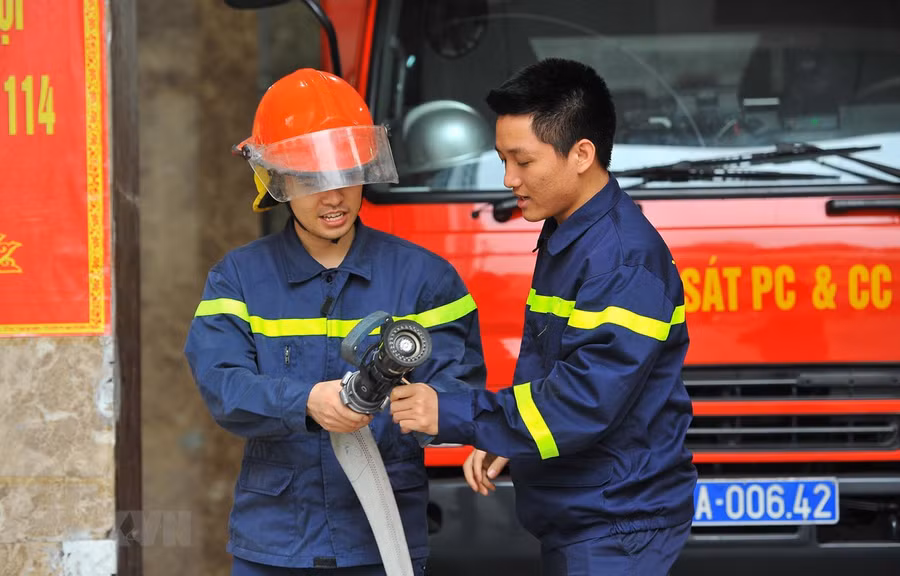 Trung úy Vũ Ngọc Hoàng (phải) hướng dẫn nghiệp vụ cho chiến sỹ mới tại đơn vị. (Ảnh: Minh Đức/TTXVN)