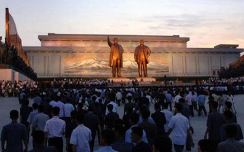 Người dân Triều Tiên đặt hoa tưởng niệm trước bức tượng đồng của Chủ tịch Kim Nhật Thành (Kim Il Sung) và nhà lãnh đạo thứ hai Kim Jong-il.