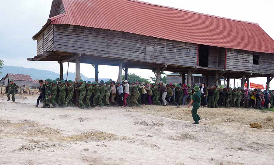  Quân và dân chung sức di dời nhà sang nơi ở mới. Ảnh: N.T