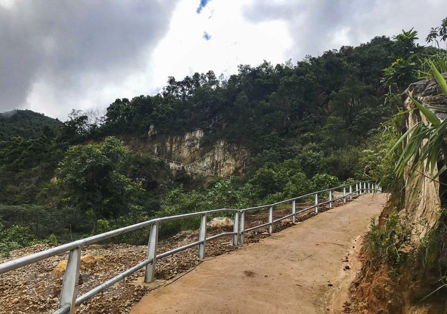 Con đường bêtông men theo các vách núi vừa được xây dựng để lên cột mốc số 0. (Ảnh: Xuân Tư/TTXVN)