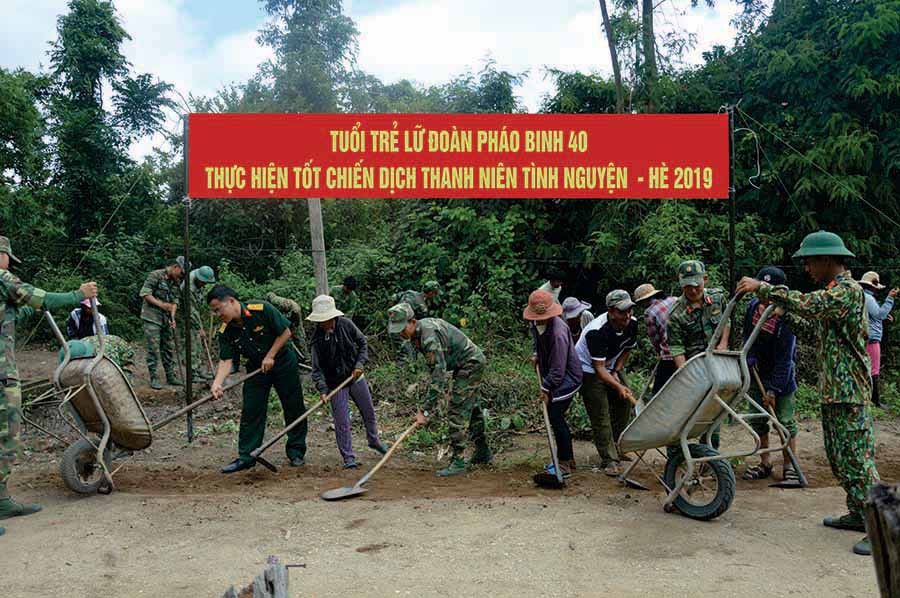  Cán bộ, chiến sĩ Lữ đoàn Pháo binh 40 (Quân đoàn 3) cùng người dân làng Hiêr (xã Ayun, huyện Mang Yang) dọn dẹp vệ sinh đường làng. Ảnh: T.B