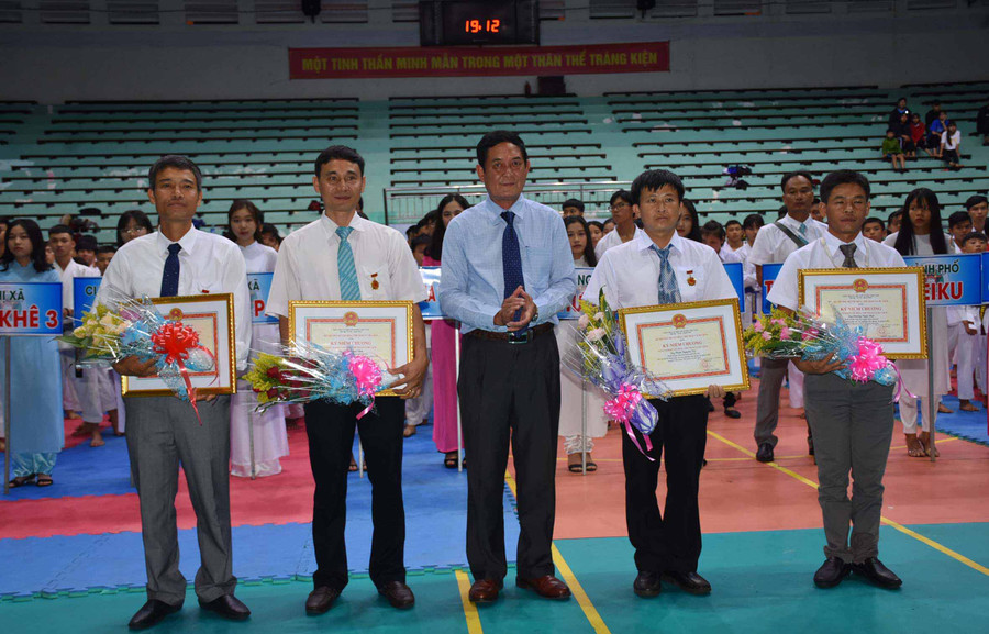 Ông Nguyễn Đức Hoàng-Phó Giám đốc Sở VH-TT và DL tỉnh Gia Lai thừa ủy quyền Bộ trưởng Bộ VH-TT và DL trao kỷ niệm chương cho các huấn luyện viên. Ảnh: Hà Phương