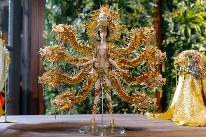 Vùng đất chín rồng của Hoàng Hữu Kha gây ấn tượng bởi sự hoành tráng của khung 9 con rồng phía sau. Chỉ sử dụng duy nhất gam màu vàng kim, bộ trang phục không chỉ đảm bảo tính thẩm mỹ, còn thể hiện văn hóa truyền thống Việt Nam, thể hiện quyền bình đẳng nam nữ, nói lên nguồn gốc tên gọi Cửu Long Giang. Ưu điểm lớn nhất của trang phục là thiết kế ôm sát cơ thể, khoe được vóc dáng, đặc biệt là đôi chân dài của Á hậu Hoàng Thùy. Tác giả bảo đảm trang phục không gây sức nặng cho Hoàng Thùy khi trình diễn- Ảnh: BTC