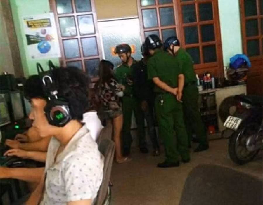  Công an giữ 2 nghi phạm tại tiệm Internet. Ảnh: NĐN