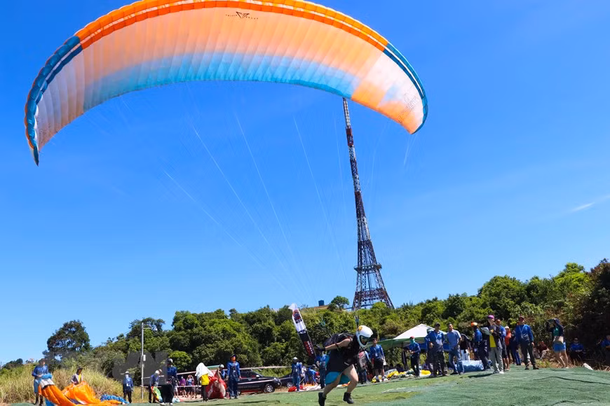 Vận động viên nữ xuất phát lượn dù tại bãi bay trên bán đảo Sơn Trà. (Ảnh: Trần Lê Lâm/TTXVN)