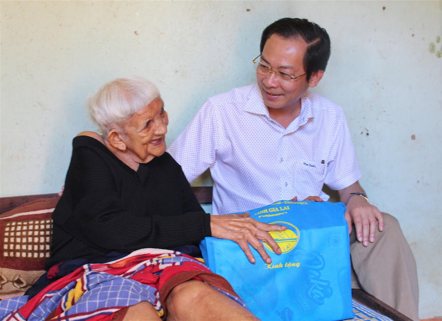 Phó Chủ tịch UBND tỉnh Đỗ Tiến Đông ân cần thăm hỏi sức khỏe bà Rơ Châm Inh (thân nhân liệt sĩ; trú tại làng Út 1, xã Ia Hrung, huyện Ia Grai. Ảnh: Hồng Thi