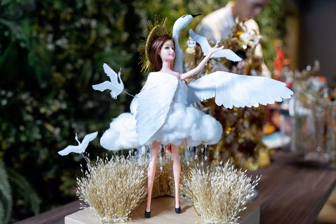 Cò của Nguyễn Đức Liêm tái hiện không gian làng quê Việt Nam qua hình ảnh đồng lúa, cò, mặt trời. Sử dụng gam màu chủ đạo là trắng và vàng, bộ trang phục khi mang lên sân khấu sẽ tạo hiệu ứng phối cảnh 3D. Tác giả đảm bảo bộ trang phục không gây khó khăn khi di chuyển, cũng như thuận tiện cho việc đóng gói khi mang đến Miss Universe-Ảnh: BTC