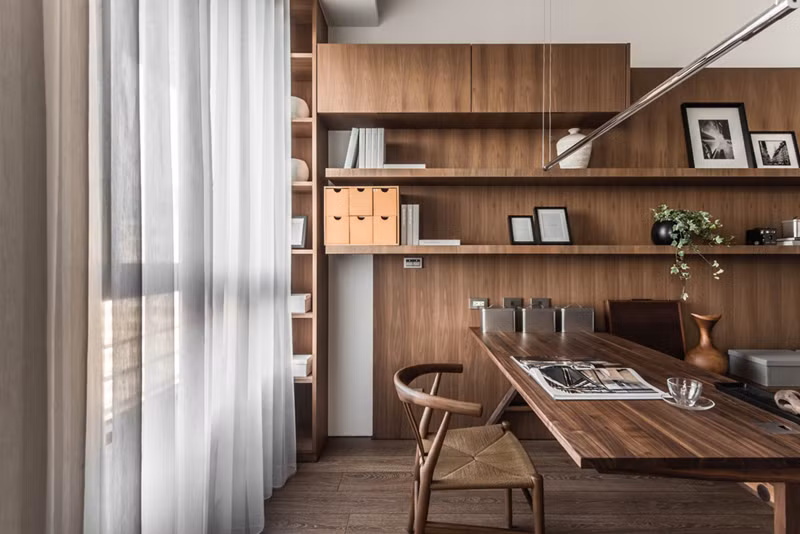  Sắp xếp các tác phẩm nghệ thuật đóng khung, bình trang trí và vật kỷ niệm trên kệ mang đến cảm giác gần gũi, thân thuộc cho khu vực văn phòng.