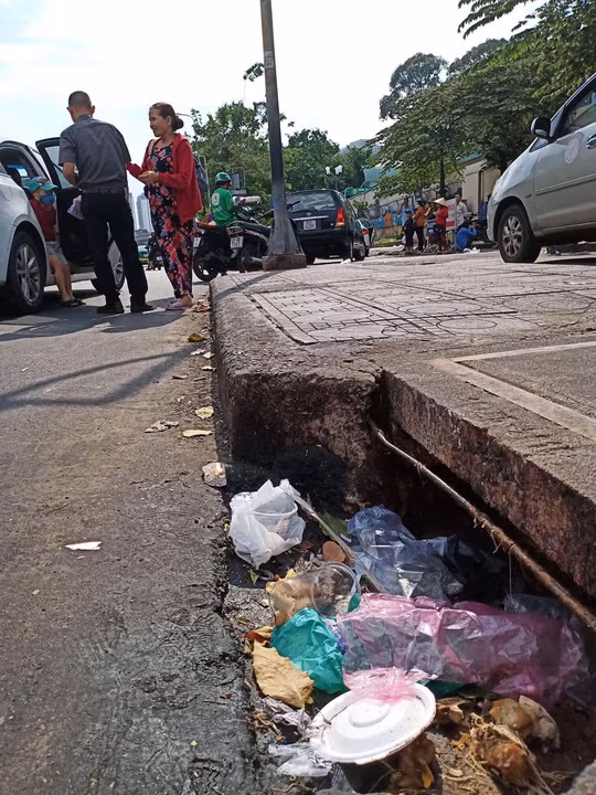  Thản nhiên bỏ rác xuống miệng hố ga với suy nghĩ đã có người khác dọn, một biểu hiện của bệnh vô cảmẢnh: Phạm Dũng