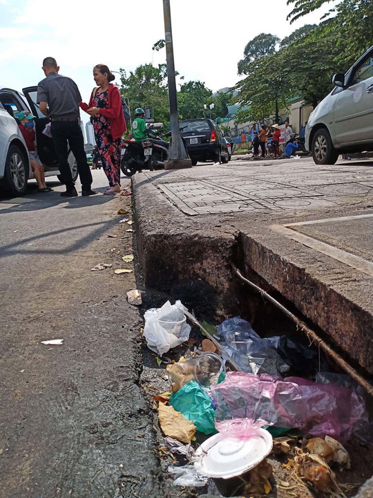  Thản nhiên bỏ rác xuống miệng hố ga với suy nghĩ đã có người khác dọn, một biểu hiện của bệnh vô cảmẢnh: Phạm Dũng