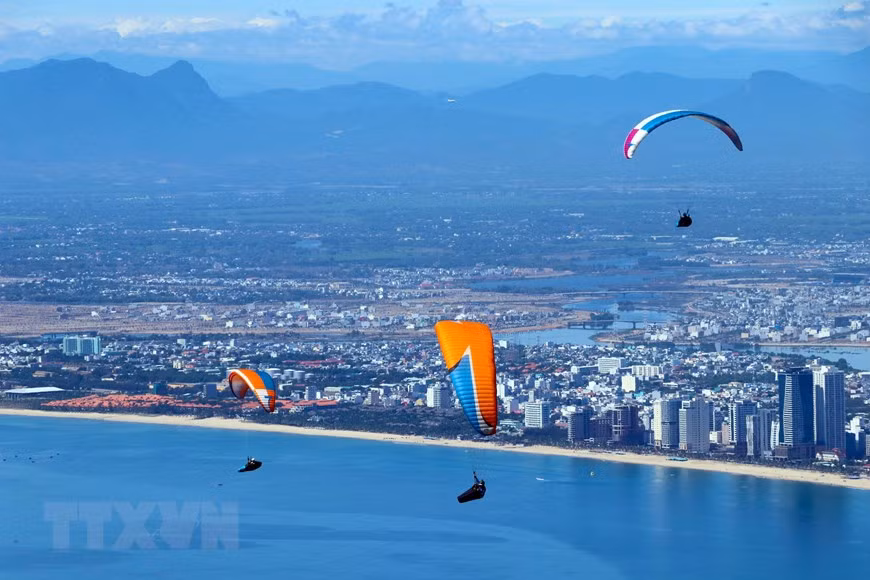 Các vận động viên biểu diễn lượn dù sau khi xuất phát. (Ảnh: Trần Lê Lâm/TTXVN)